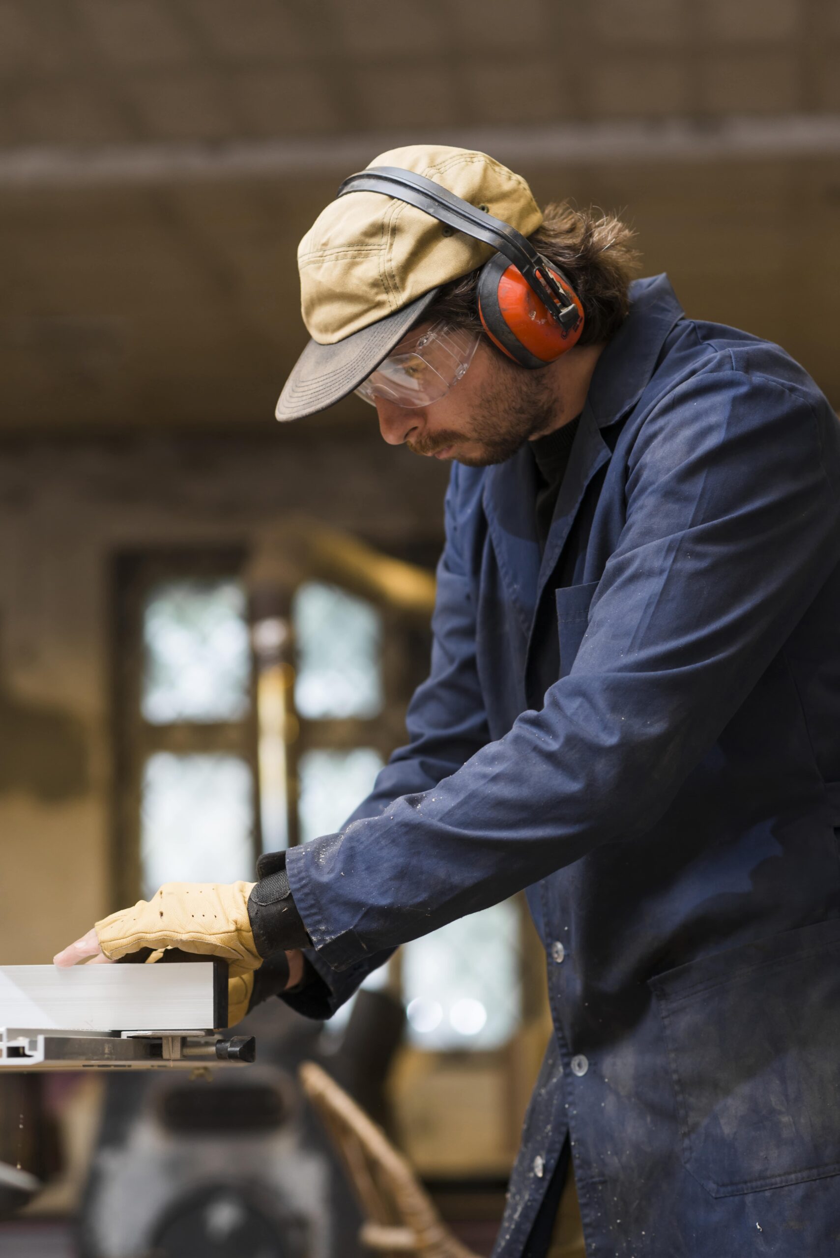 portrait-male-carpenter-wearing-ear-defender-working-workshop-min